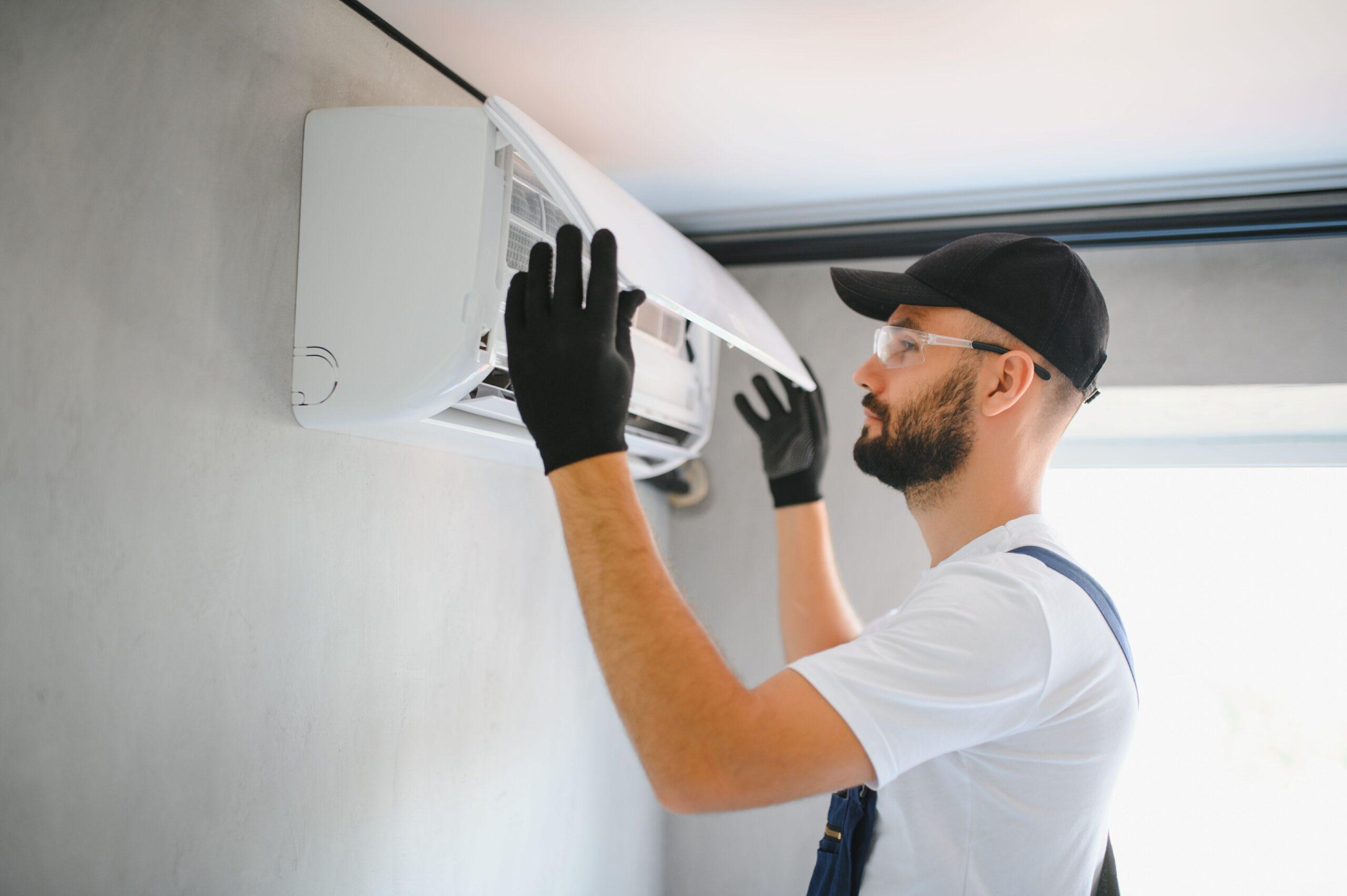 Eine Person montiert einen Lüfter oben an der Wand 